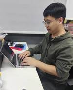 人拿著筆記本電腦的桌子前描述已自動(dòng)生成